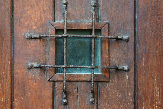 Window with grate in old wooden door