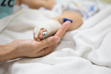 Mother holding a baby hand.