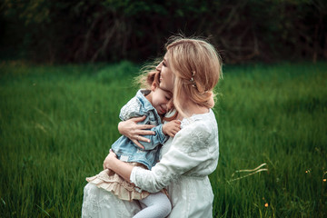 A mother and child in nature. The little girl clung to the mother. The concept of life values, peace, security and love