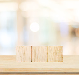 Three wooden cubes on table and blur abstract background