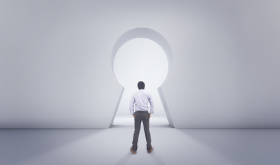 Asian Man Standing In Front of Big Lock Hole Door