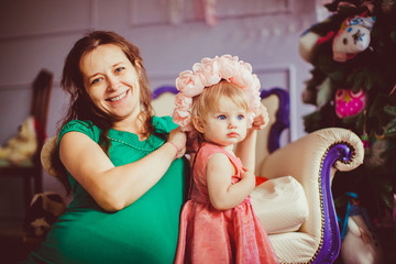Little baby in the wreath from pink flowers