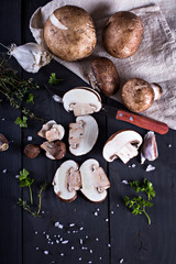 Obraz na płótnie Canvas Fresh mushrooms with spices and herbs on a black board.Champignon mushrooms