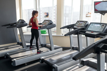 Sports woman is running on the treadmill