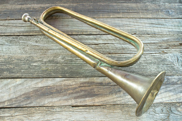 Obraz premium Old broken army trumpet on wooden background