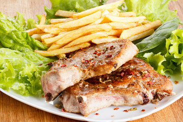 Juicy roasted pork steak with french fries and spices