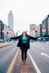 young handsome caucasian reddish straight hair woman in the middle of the street with arms wide open - freedom, girl power, goal concept