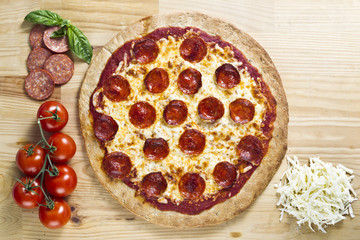 close-up image of pizza with tomatoes, cheese and slices of ham.