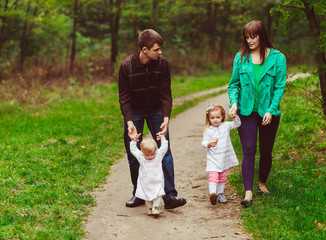 Fototapeta premium Happy walk of the young parents and their kids