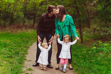 Fototapeta premium Young emotional family in the forest with kids