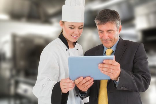 Composite image of businessman and female chef using digital tab