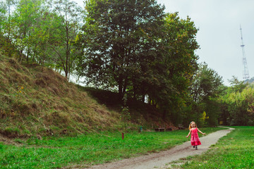 Obraz premium Happy little girl runs in the park