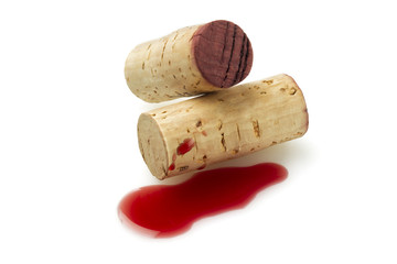 two bottle corks and red wine.
