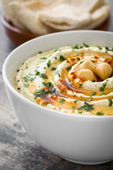 Hummus with pita bread on rustic wood