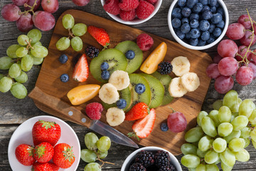 ingredients for fruit salad on wooden board, top view