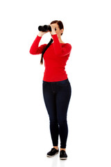 Young woman looking through a binocular