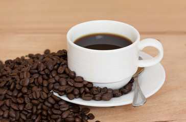 Coffee cup and coffee beans on table