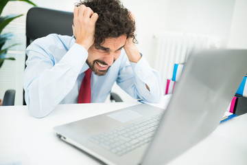 Angry businessman looking at his computer