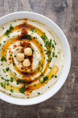 Hummus in bowl on a rustic wooden table
