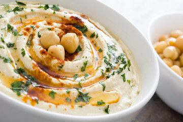 Hummus in bowl on a rustic wooden table
