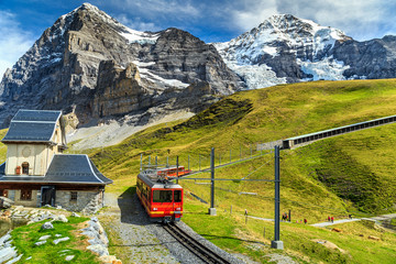 Fototapeta premium Elektryczny pociąg turystyczny i Eiger North face, Oberland Berneński, Szwajcaria