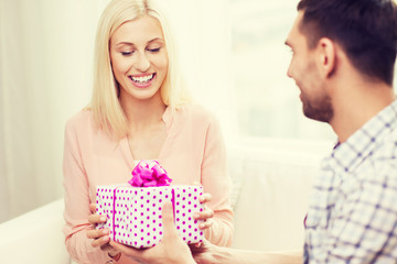 happy man giving woman gift box at home
