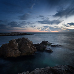Fototapeta premium Sea coast under blue sky with clouds at sunset