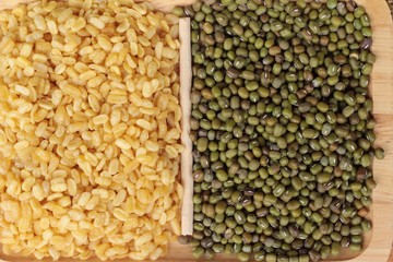 Soy beans and dry beans on wood background.