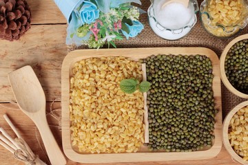 Soy beans and dry beans on wood background.