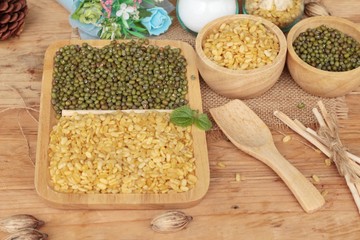 Soy beans and dry beans on wood background.