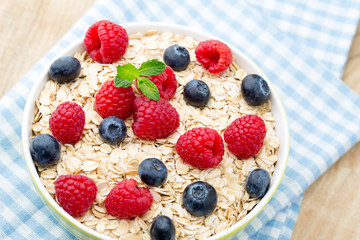 Oatmeal porridge with berries. Raspberries and blueberries.