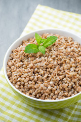 Buckwheat porridge in a bowl with mint leaves and blueberries.