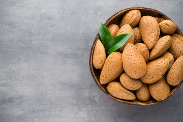 Group of almond nuts with leaves.Wooden background.