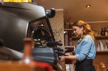 barista woman making coffee by machine at cafe
