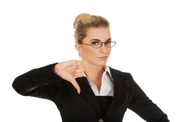 Unhappy young businesswoman with thumbs up