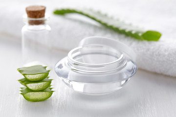 Empty cream container and bottle for spa cosmetic product and white towel on white background