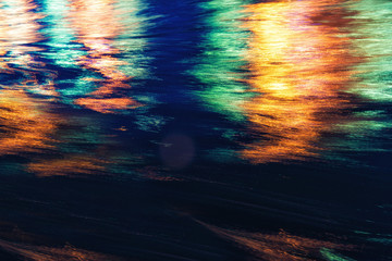 City lights reflection. Colorful glare on the water