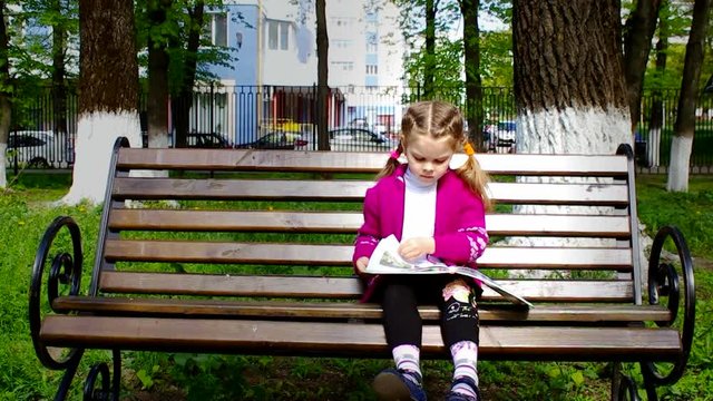 Girl reading a book while sitting on the bench shooting slider