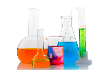 Different laboratory glassware with color liquid with reflection on white background