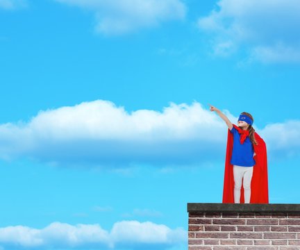 Composite image of masked girl pretending to be superhero