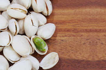 roasted and salted pistachios on wooden background