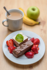 Chocolate and vanilla dessert with strawberries and coffee