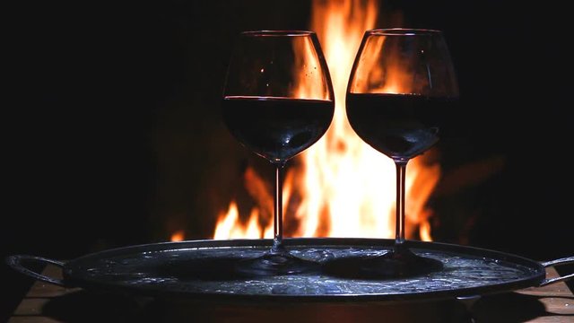 Two glasses of wine with flame on background
