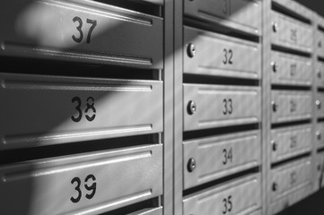 grey metallic mailbox array inside apartment houses