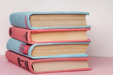 Stack of colorful books, grungy blue background, free copy space. Education essential for self improvement, gaining knowledge and success in our careers, business and personal lives.