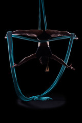 Young woman gymnast with blue gymnastic aerial silks
