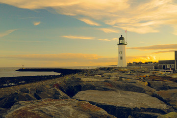 Classic lighthouse / Old Scituate lighthouse on a cloudy sky background during sunset