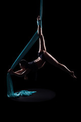 Young woman gymnast with blue gymnastic aerial silks