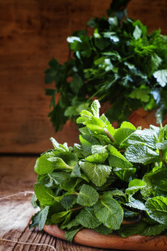 Fresh peppermint and other herbs, wood background, country style