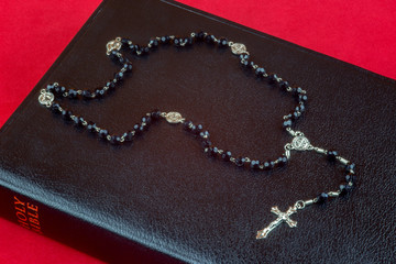 Rosary Beads and Crucifix on Closed Bible
